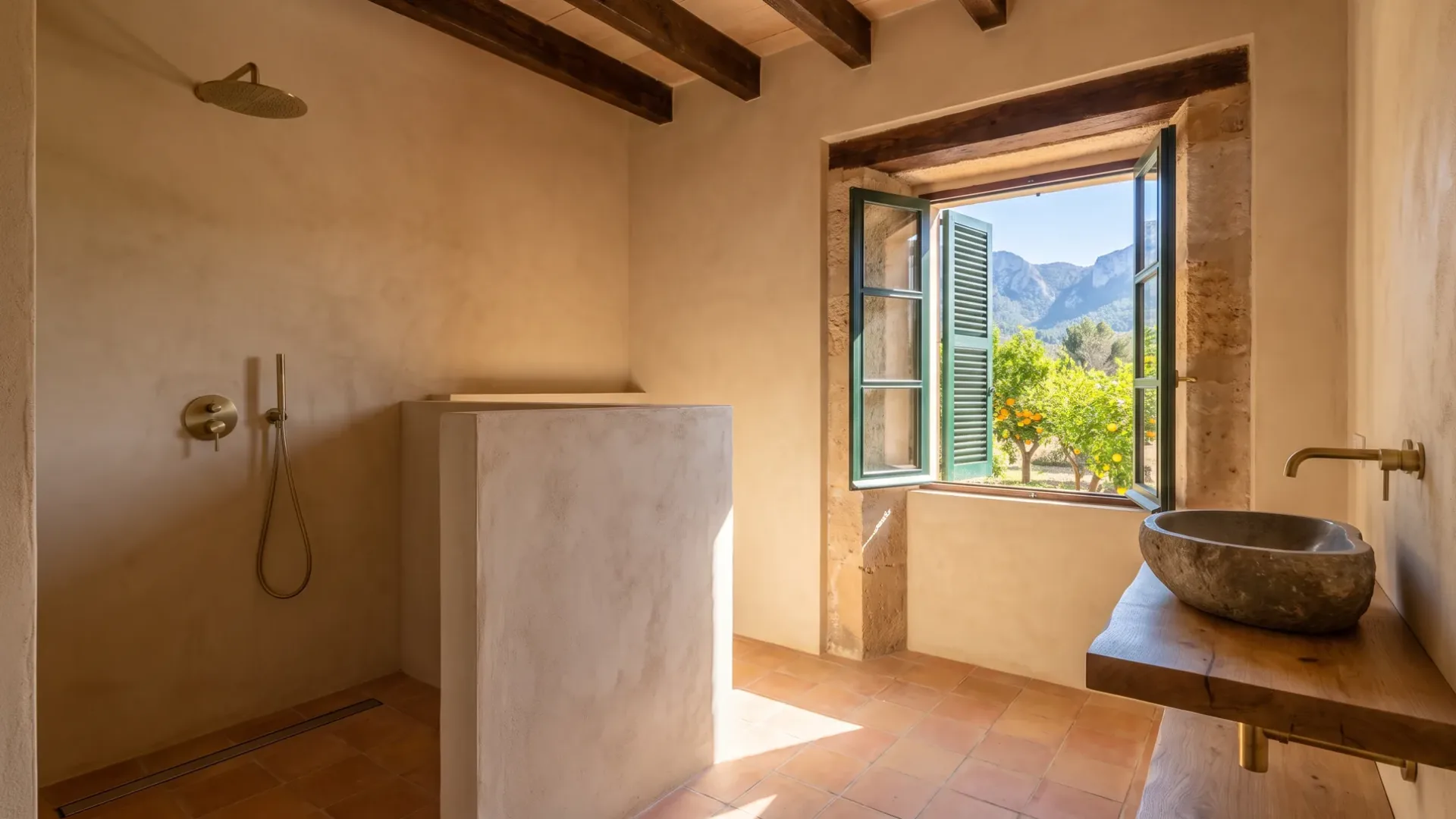 An open shower behind a waist-high plaster wall, a stone basin on an oak shelf and a window onto orange trees and mountains.